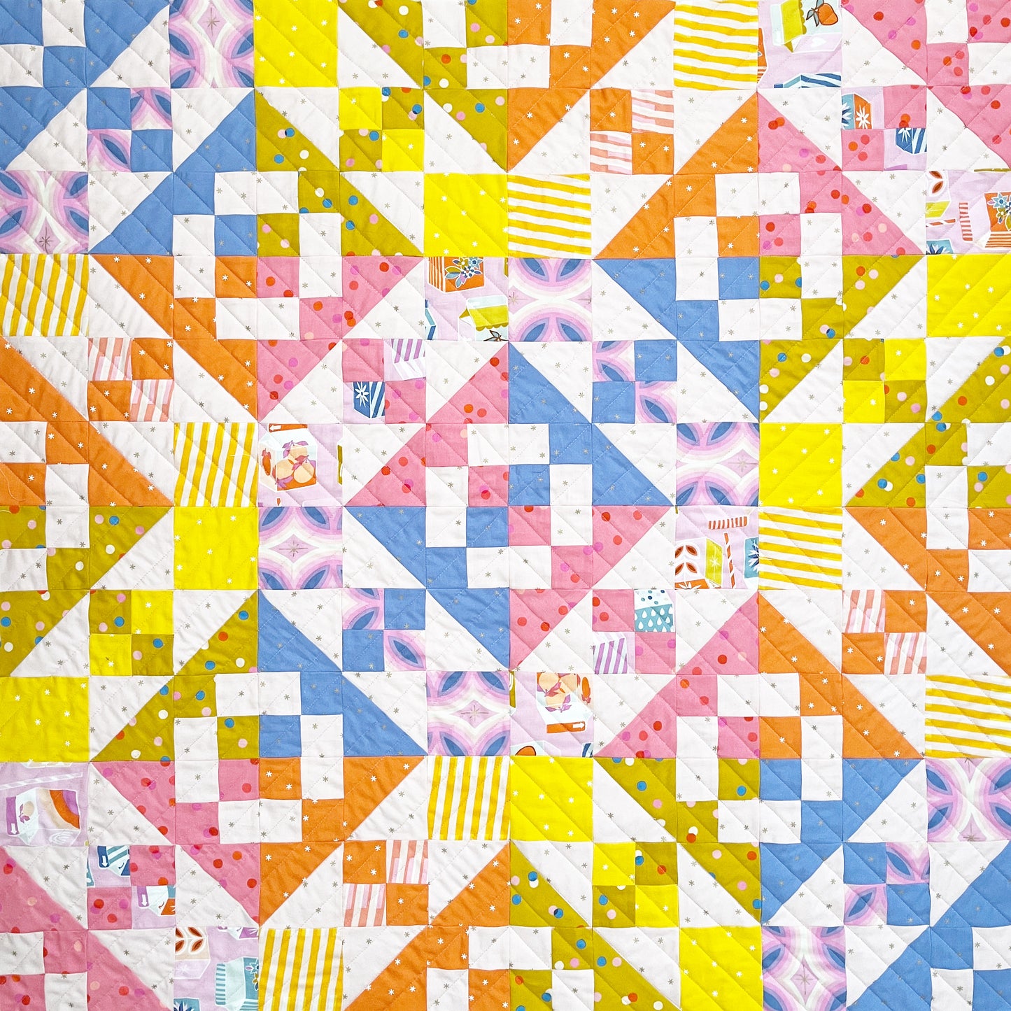 Colorful quilt with geometric pattern in Ruby Star clementine fabrics