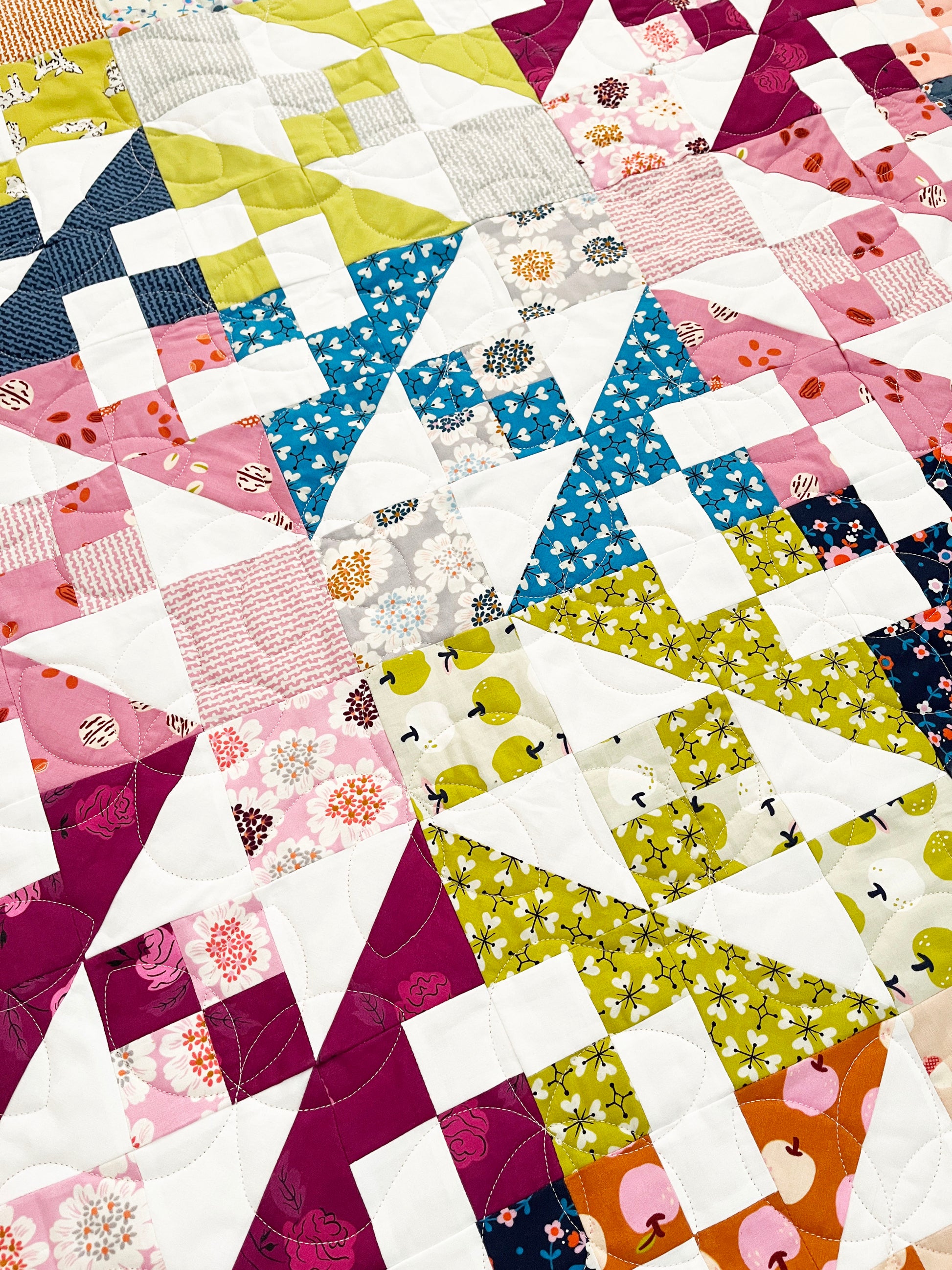 Colorful quilt with various patterned fabric pieces.