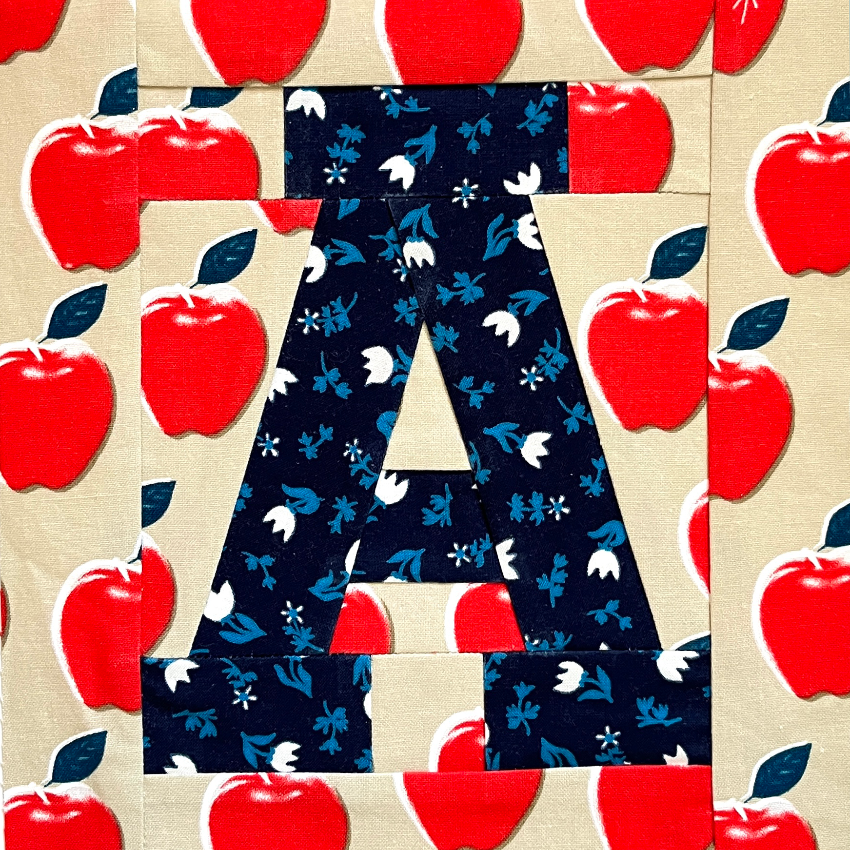 Paper piecing varsity letter quilt block detail, letter A on apple print fabric