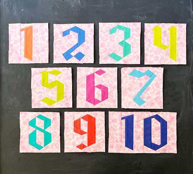 FPP number blocks in bright colors on a neon fabric background, arranged against a chalkboard.