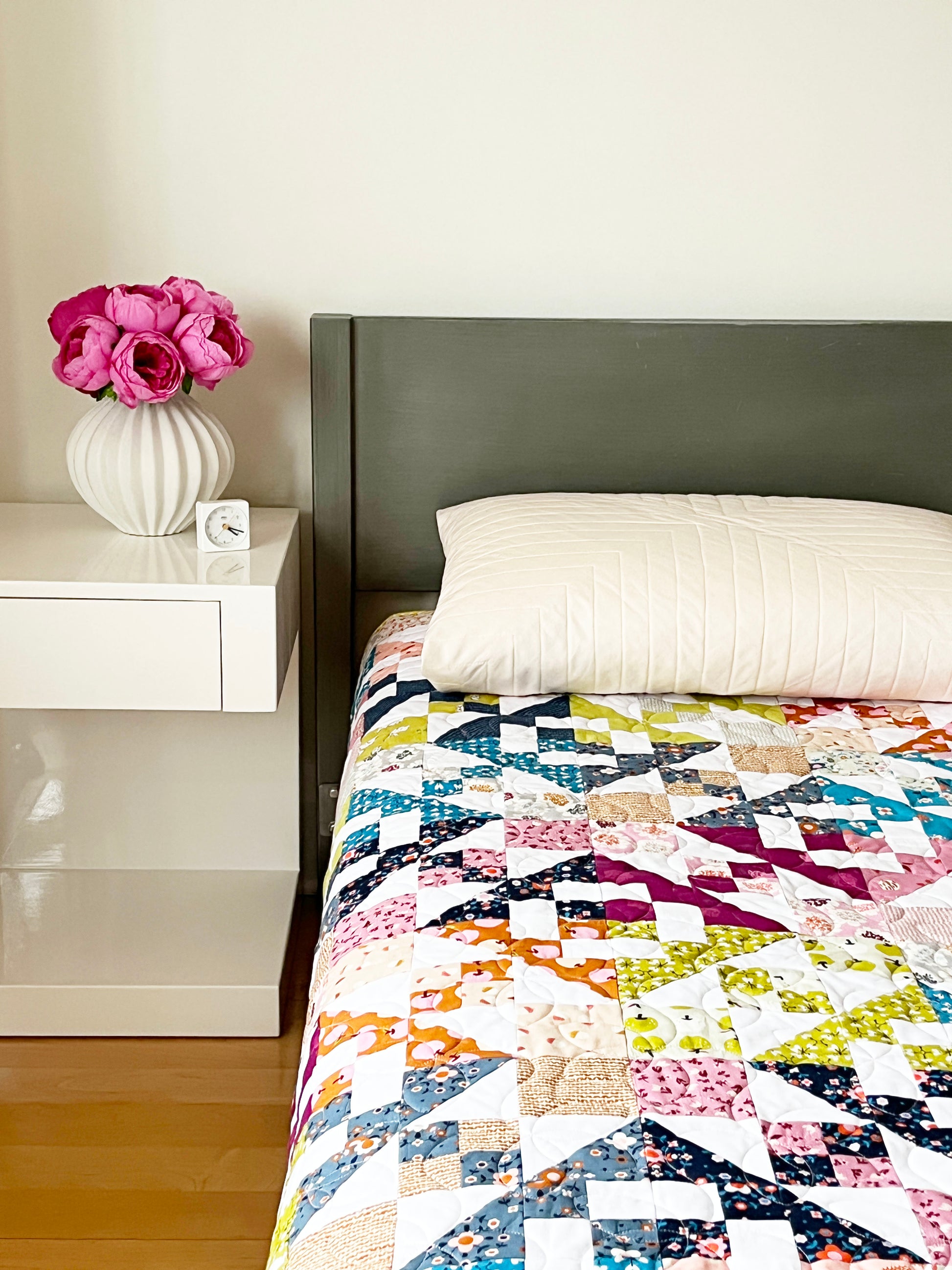 Sugarcubes quilt pattern with colorful classic geometric blocks on bed